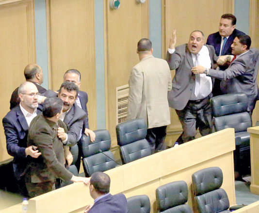 Deputies try to rein in MP Mohammad Hudeib and MP Khaled Fanatsah after a brawl broke out between them during a Lower House emergency session on Monday (Photo courtesy of Amir Khalifah)