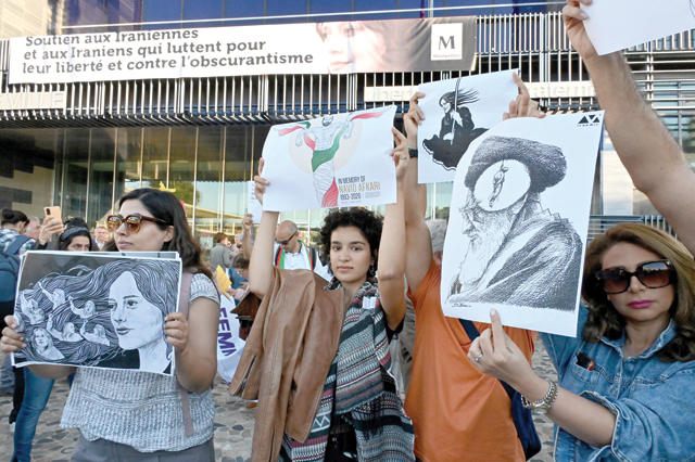 Women protest with placards during the unveiling of a banner on the facade of the town hall in support of the Iranians fighting for their freedom and against obscurantism in their country, in Montpellier, southern France, on Monday (AFP photo)