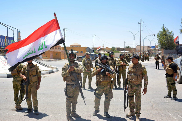 Iraqi government forces celebrate with national flags on a street on Thursday in the western town of Rutba after they recaptured it from the Daesh terror group (AFP photo)