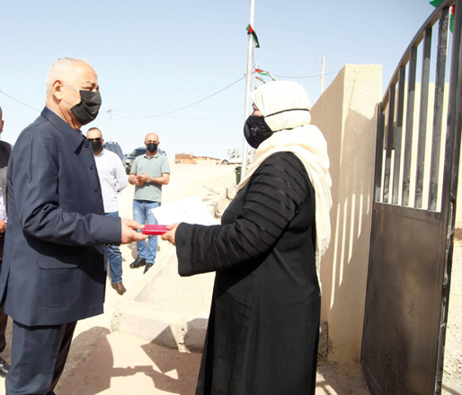 Royal Court Chief Yousef Issawi hands over key of houses to new houses to a in Karak on Saturday upon Royal initiative for housing (Petra photo)