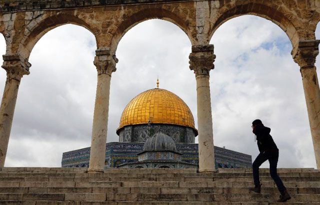 A pedestrian walks past the Dome of the Rock at Al Aqsa Mosque compound in the Old City of Jerusalem (AFP photo)