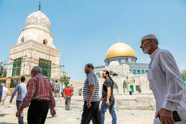 Men walk near the Dome of the Rock at Al Aqsa Mosque compound in the Old City of Jerusalem on Friday  (AFP photo)