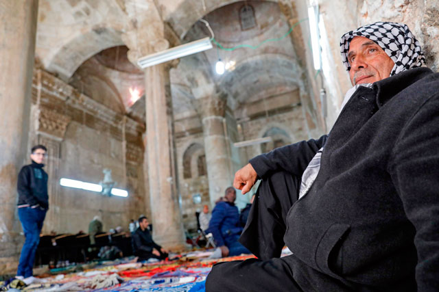   A Palestinian Muslim worshipper sits by a wall inside Bab Al Rahmah (Gate of Mercy), inside Al Aqsa Mosque complex in the Old City of Jerusalem, on Sunday (AFP photo)