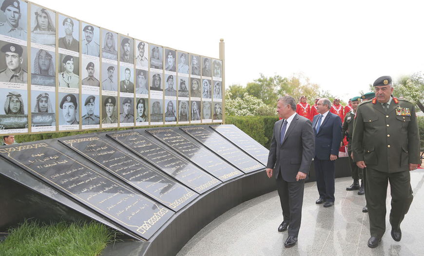 His Majesty King Abdullah views the photos of soldiers killed in action during the 1968 Karamah Battle during a ceremony at a Jordan Valley memorial on Tuesday  (Photo courtesy of Royal Court)