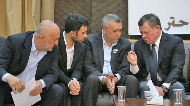 His Majesty King Abdullah speaks to relatives of late writer Nahed Hattar in Fuheis on Thursday (Photo courtesy of Royal Court)