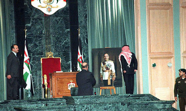 In this photo taken on February 7, 1999, His Majesty King Abdullah stands before a photo of His Majesty the late King Hussein in Parliament before taking the oath to assume his constitutional powers (Petra file photo)