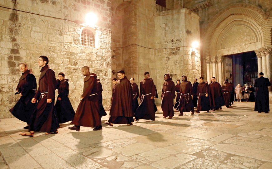 Franciscans friars leave the Church of the Holy Sepulchre, traditionally believed to be the site of Jesus' crucifixion, burial and resurrection, in the Old City of Jerusalem after night prayer on Sunday  (AFP photo)