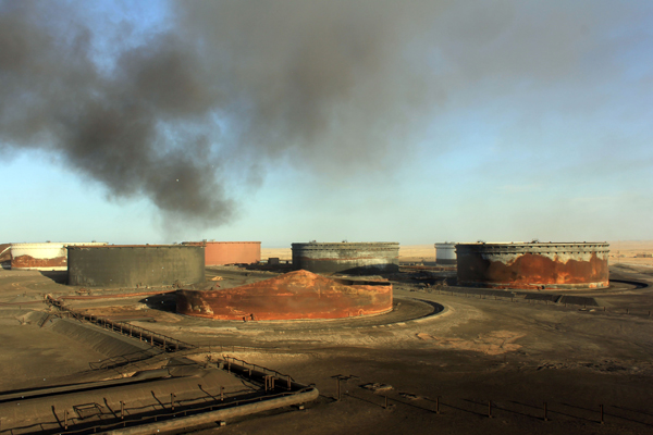 This file photo taken on January 8 shows smoke billowing from a petroleum storage tank after a fire was extinguished following fighting at Al Sidra oil terminal, near Ras Lanuf in the so-called ‘oil crescent’ along Libya’s northern coast (AFP photo)