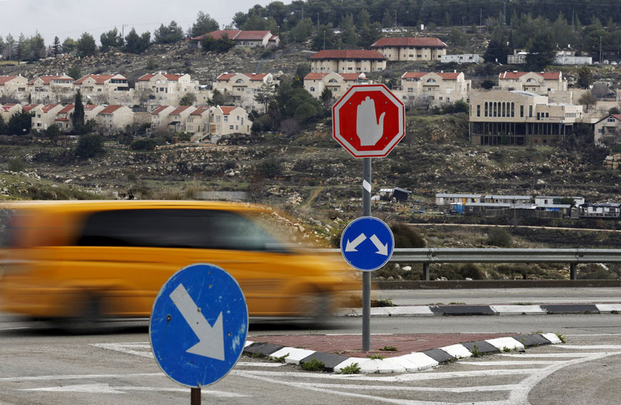 A car drives past houses in the West Bank Jewish settlement of Efrat on Wednesday. The United States, European Union and the United Nations have issued unusually stern criticism of Israel for its settlement activity in occupied lands (Reuters photo by Amir Cohen)
