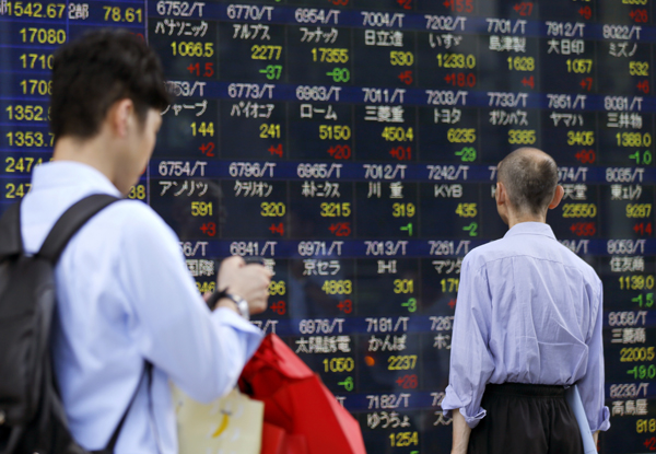 A man looks at an electronic stock indicator of a securities firm in Tokyo, Tuesday (AP photo)