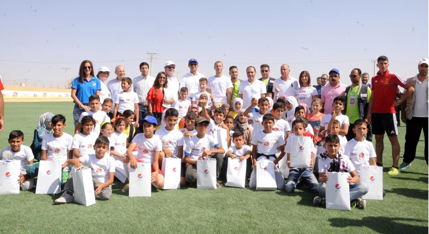 HRH Prince Ali poses for a group photo during the opening of a new artificial football pitch in the Zaatari Refugee Camp on Tuesday (Photo courtesy of PepsiCo)