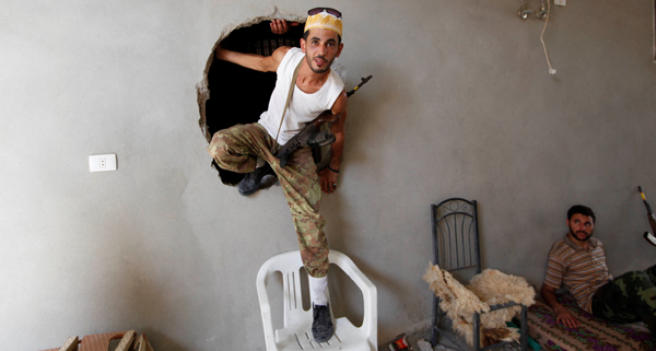 A fighter from Libyan forces allied with the UN-backed government climbs out of a hole during a fight with the Daesh terror group in neighbourhood Number Three in Sirte, Libya, on Sunday (Reuters photo)