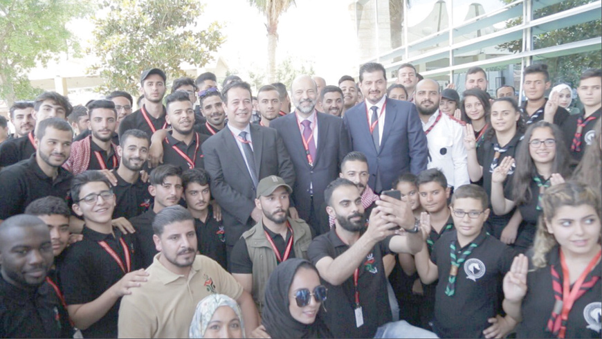 Prime Minister Omar Razzaz and Minster of Culture and Youth Mohammad Abu Rumman pose for a photo with young Jordanians during a ceremony to launch the National Strategy for Youth on Monday (Photo courtesy of Prime Ministry)