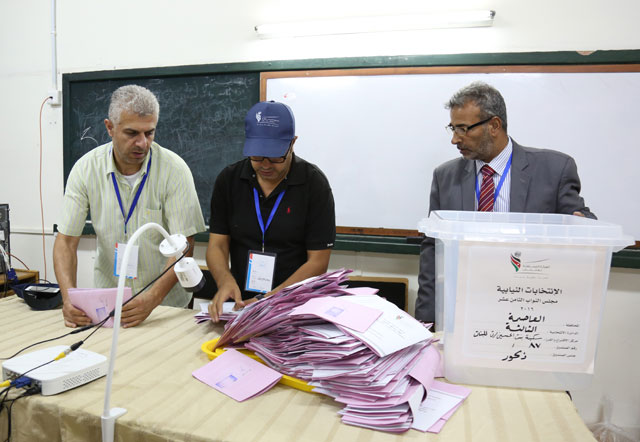Members of an electoral committee in Amman’s 3rd District sort ballots after voting ended late on Tuesday (Photo by Raad Adayleh)