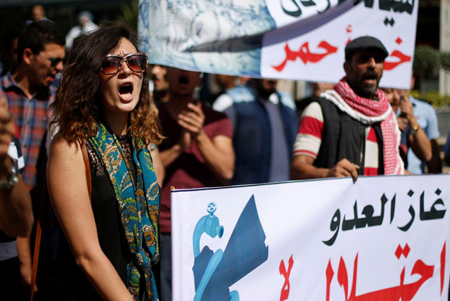 Protesters chant slogans during a demonstration against a government agreement to import natural gas from Israel, in Amman, on Friday. The placard reads: ‘The enemy’s gas is occupation’  (Reuters photo by Muhammad Hamed)