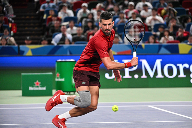 Serbia's Novak Djokovic hits a return to USA's Alex Michelsen during their men's singles match at the Shanghai Masters tennis tournament in Shanghai on Saturday (AFP photo)