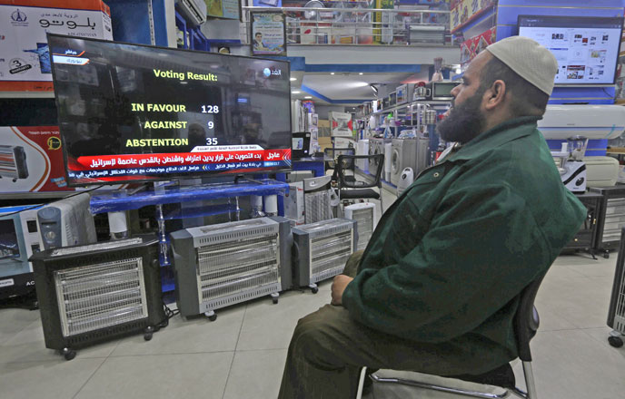 A Palestinian man watches a televised broadcast of the UN General Assembly vote on a draft resolution calling on the United States to withdraw its recognition of Jerusalem as Israel's capital, at an electrical appliances store in Gaza Strip, on Thursday (Reuters photo)