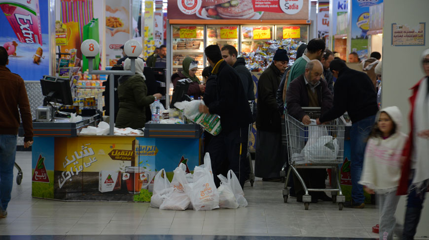 Shoppers check out of a hypermarket in Amman recently. The Trade Ministry on Thursday urged consumers not to overstock on supplies in preparation for the cold weather expected next week (Photo by Amjad Ghsoun)