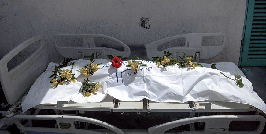 A body unearthed at Nasser Hospital is set on a stretcher and covered with flowers for burial, in Khan Yunis in the southern Gaza Strip on Tuesday (AFP photo)
