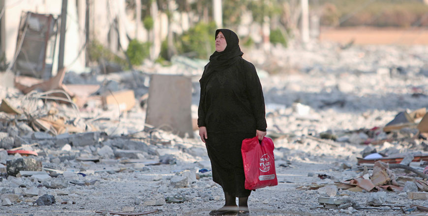 A woman stands along a damaged street in Manbij, Aleppo Governorate, Syria, on Tuesday (Reuters photo)
