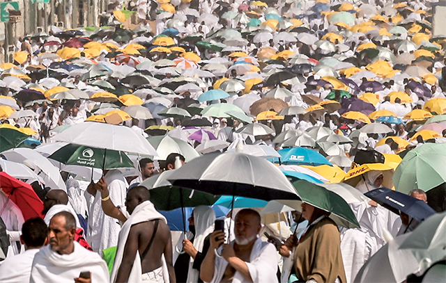 Muslim pilgrims use umbrellas to shade themselves from the sun as they arrive at the base of Mount Arafat, also known as Jabal Al Rahma or Mount of Mercy, during the annual Hajj pilgrimage on June 15, Friends and family searched for missing Hajj pilgrims on June 19 as the death toll at the annual rituals, which were carried out in scorching heat, surged past 900 (AFP photo)