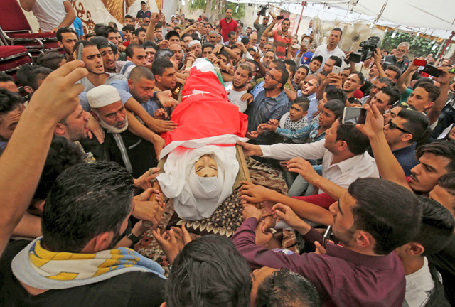 Mourners carry the body of 16-year-old Mohammad Jawawdeh, who was killed on the weekend during an argument with a security guard at the Israeli embassy compound in the Jordanian capital, during his funeral in Amman on Tuesday (AFP photo)