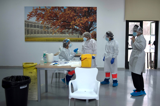Healthcare workers wait for residents to be tested for COVID-19 at a temporary testing centre in Ronda, Spain, on Wednesday (AFP photo)
