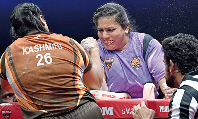 Farheen Dehalvi of Baroda Badshahs (centre) competes against Kashmiri Kashyap of Ludhiana Lions during the professional arm wrestling tournament in New Delhi (AFP photo)