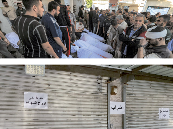 People gather by the wrapped bodies of victims who died in an overnight blast at the Ahli Arab hospital in central Gaza on Wednesday. (AFP photo by Mahmud Hams)  Shops are seen closed in Amman on  Wednesday in mourning over the death of innocent lives in Gaza  (Photo by Osama Aqarbeh)