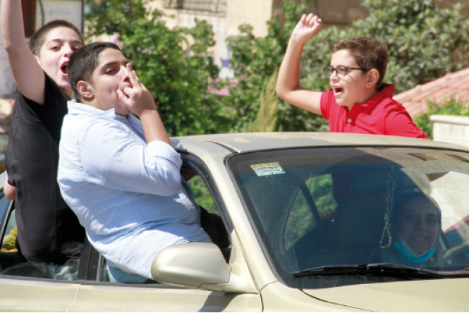 Students are seen celebrating after the announcement of the 2021 General Secondary Education Certificate Examination (Tawjihi) on Monday (Photo by Abdullah Ayoub)