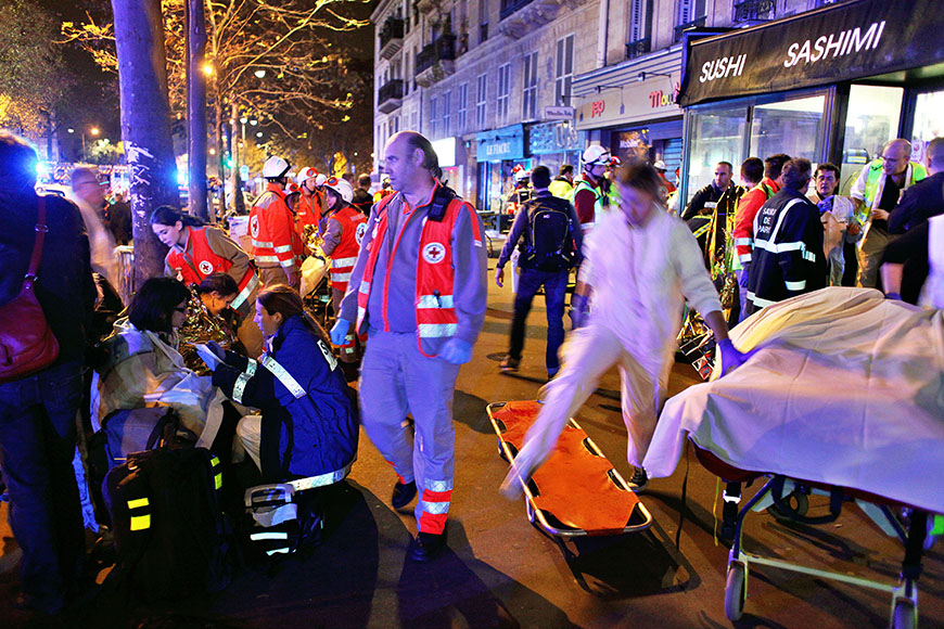 People rest on a bench after being evacuated from the Bataclan theater after a shooting in Paris, Saturday, Nov. 14, 2015 (AP Photo/Thibault Camus)