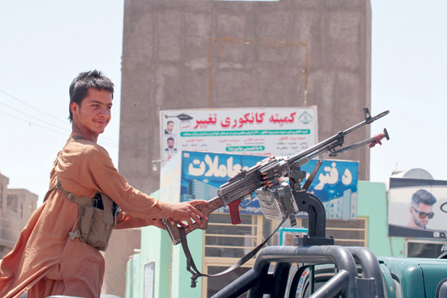 In this photo taken on Friday, an Afghan militiaman stands on a vehicle keeping a vigil along a road on the outskirts of Herat (AFP photo)