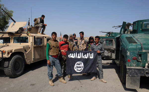 In this  August 1 photo, Afghan police pose for a photo with a Daesh terror group flag after an operation in the Kot district of Jalalabad province east of Kabul, Afghanistan (AP photo)