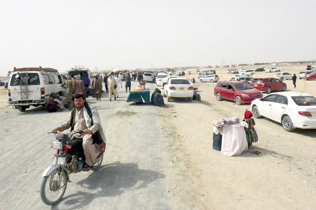 Stranded people gather at the Pakistani border town of Chaman on Wednesday, after the Taliban claimed they had captured the Afghan side of the border crossing of Spin Boldak along the frontier with Pakistan (AFP photo)