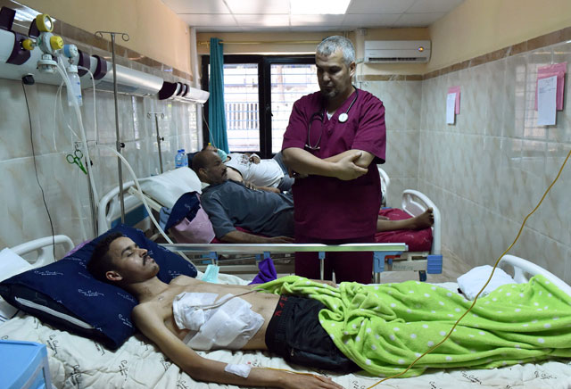 Algerian doctor Ahmed Bougroura (right), head of nephrology department at Batna's university hospital, 435km east of Algiers, talks to a transplanted patient on July 26 (AFP photo)
