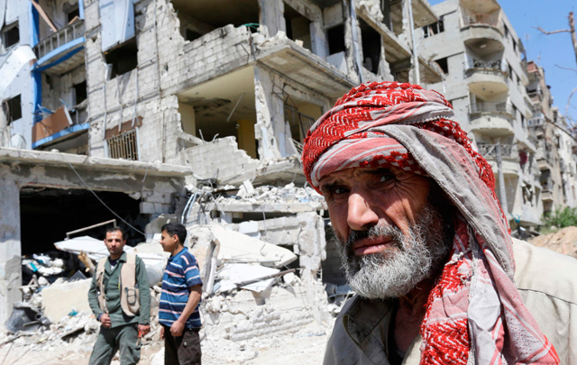 Syrians walk in the street in Douma on the outskirts of Damascus on Monday during an organised media tour after the Syrian army declared that all anti-regime forces have left Eastern Ghouta (AFP photo)