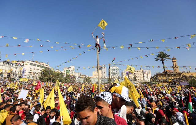 Fateh supporters wave the party flag as they take part in a rally in Gaza City on Saturday, marking the anniversary of the death of Palestinian leader Yasser Arafat (AFP photo)