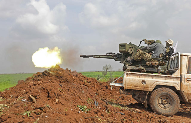 Turkish-backed Syrian opposition fighters fire an anti-aircraft gun during battles with Kurdish fighters on the outskirts of the town of Jandairis, in the region of Afrin, near the Turkish border on Wednesday (AFP photo)
