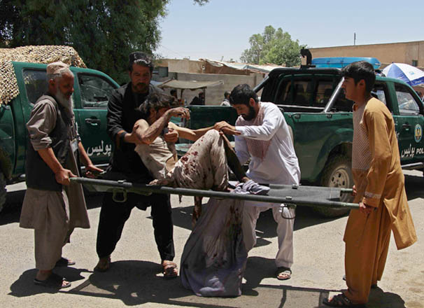 Afghan men carry a victim of a powerful car bomb in Lashkar Gah, the capital of Helmand province, on Thursday (AFP photo)