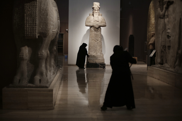 In this Sunday, March 13 photo, Iraqi workers mop the floor at the Assyrian Hall of the Iraq National Museum in Baghdad (AP photo)