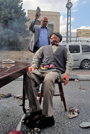 A Palestinian man uses a slipper to hit an effigy depicting Arthur Balfour, during a protest in the West Bank city of Bethlehem, on Wednesday (Reuters photo)
