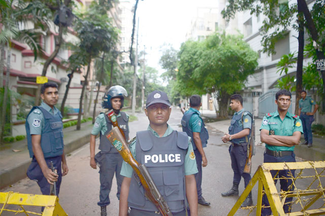 Bangladeshi policemen guard a checkpoint on a road block leading to the Holey Artisan Bakery, the scene of a fatal attack and siege, in Dhaka, on Sunday (AFP photo)