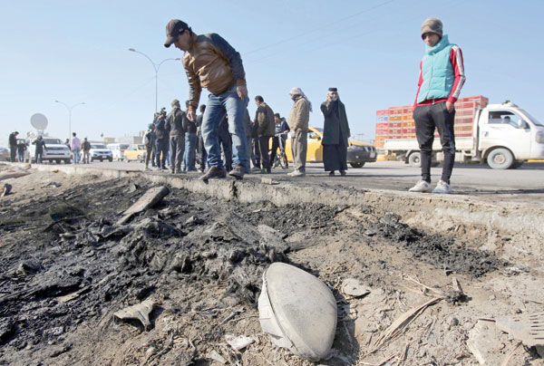 People gather at the scene of a car bombing near an outdoor market in a mostly Shiite neighbourhood of Baghdad, Iraq, on Thursday (AP photo)