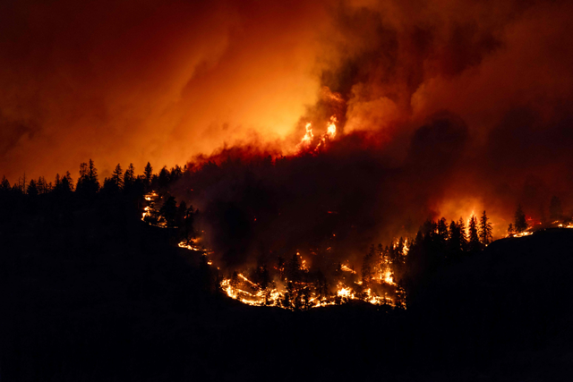 The McDougall Creek wildfire burns in the hills West Kelowna, British Columbia, Canada, on August 17, 2023, as seen from Kelowna. Evacuation orders were put in place for areas near Kelowna, as the fire threatened the city of around 150,000 (AFP photo)