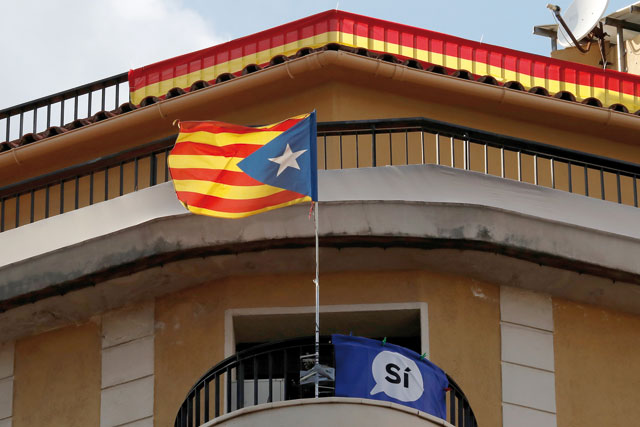 An Estelada (Catalan separatist flag) banner that reads ‘Yes’, and a Spanish flag hang from balconies in Barcelona, Spain,  on Saturday (Reuters photo)