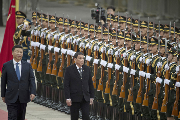 Philippine President Rodrigo Duterte (centre) walks with Chinese President Xi Jinping during a welcome ceremony outside the Great Hall of the People in Beijing, China, on Thursday (AP photo)