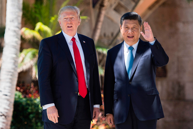 Chinese President Xi Jinping (right) waves to the press as he walks with US President Donald Trump at the Mar-a-Lago estate in West Palm Beach, Florida, on Friday (AFP photo)