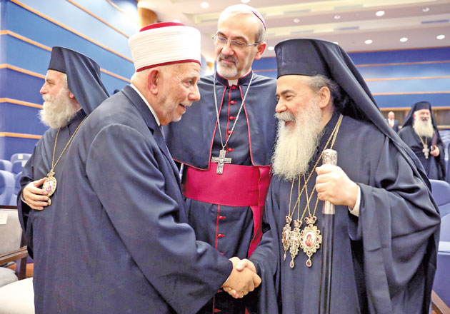 Greek Orthodox Patriarch of Jerusalem Theophilos III greets an unidentified Muslim Cleric as Apostolic Administrator of the Latin Patriarchate of Jerusalem Archbishop Pierbattista Pizzaballa looks on, at the start of an event attended by His King Abdullah, at the Baptism Site Convention Centre, Dead Sea, Jordan, on Sunday (Reuters photo)