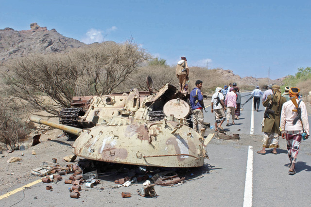Yemeni fighters loyal to the government backed by the Saudi-led coalition gather around the destroyed turret and body of a tank, near the town of Al Shurayja in the southern Lahij province, about 66 kilometres southwest of the city of Taez, on Tuesday (AFP photo)