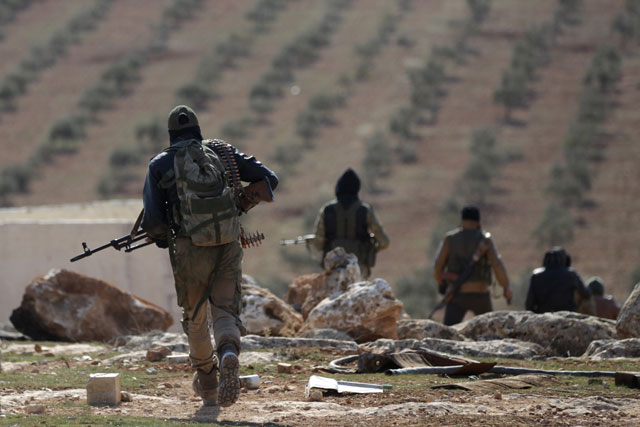 Rebel fighters carry their weapons as they walk on the outskirts of the northern Syrian town of Al Bab on Wednesday (Reuters photo)
